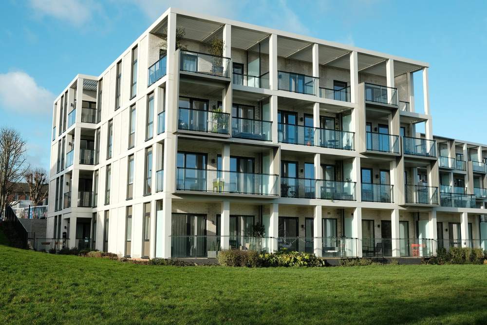 Modernes Mehrfamilienhaus mit Balkonen und Glasgeländern